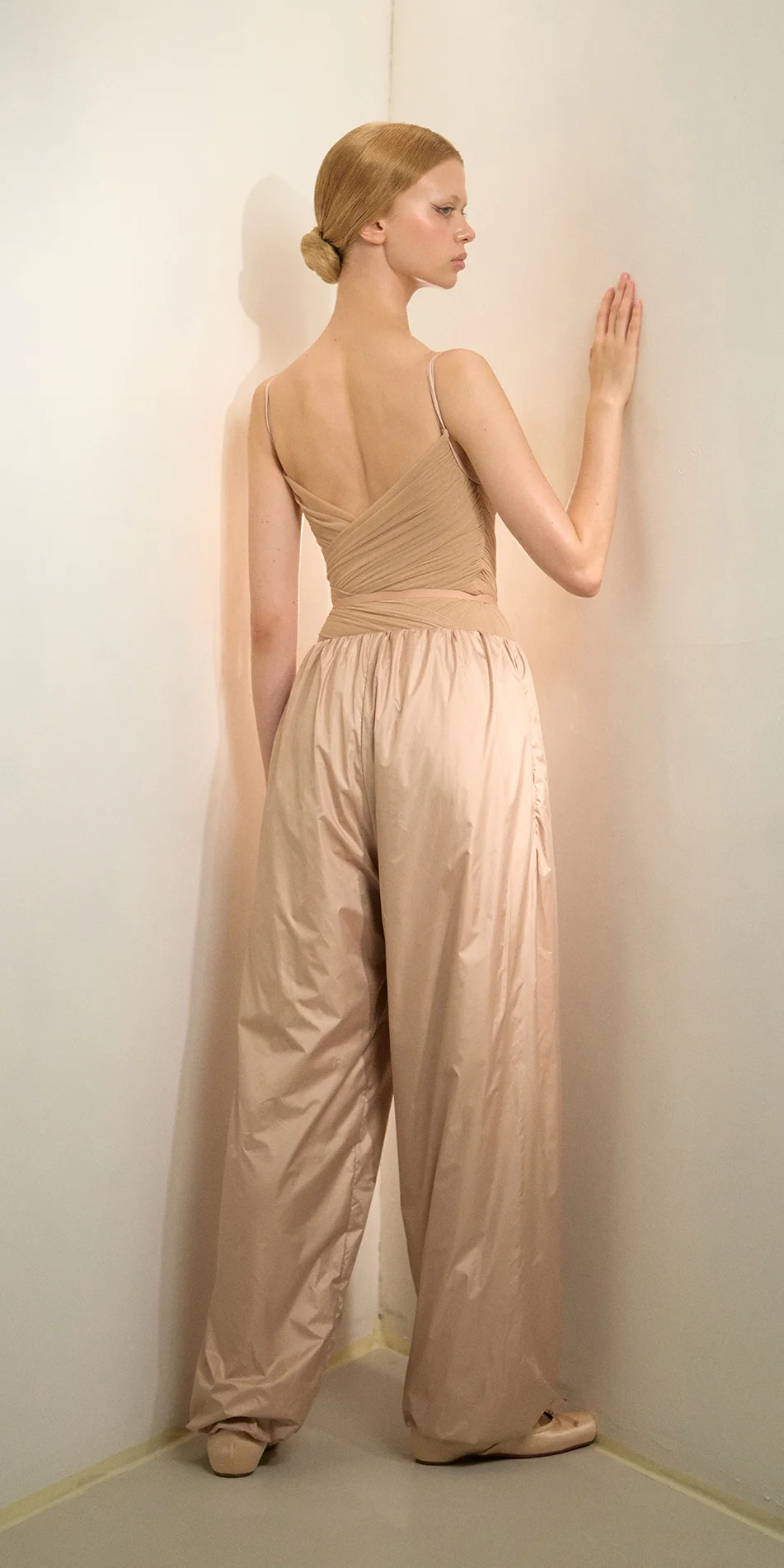 Womens lightweight baggy pants in light beige back one arm up