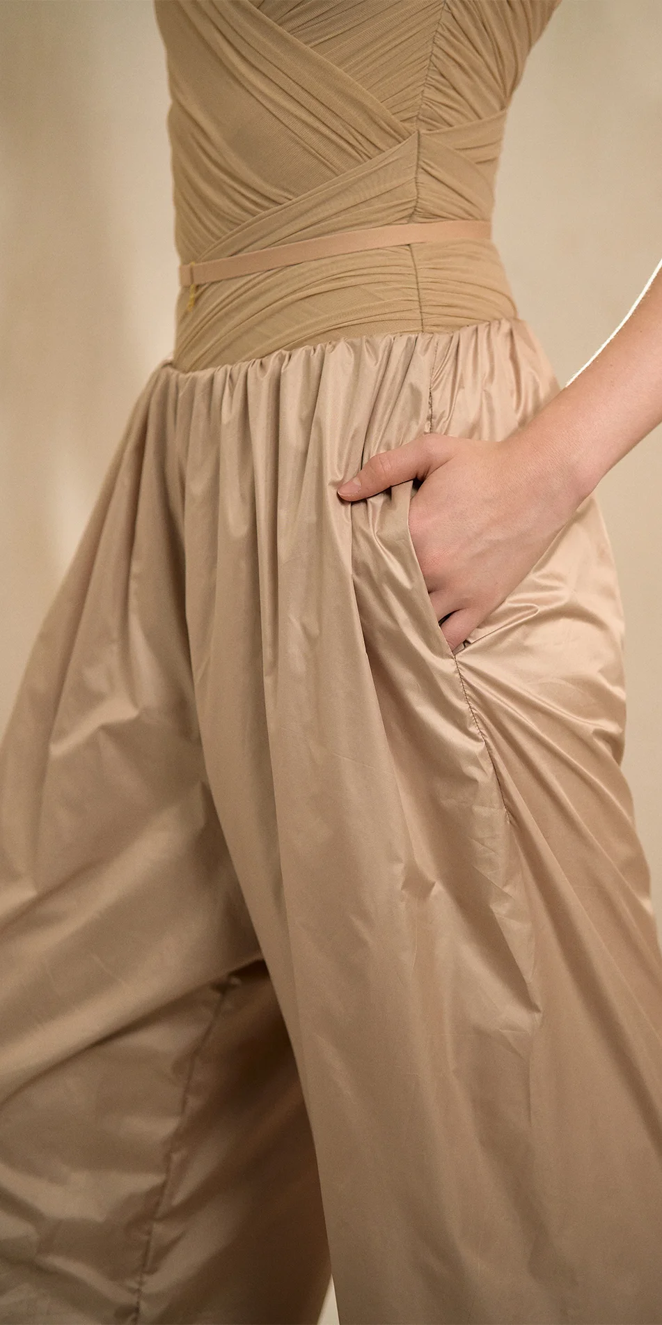 Womens lightweight baggy pants in light beige close up of hand in the pocket right