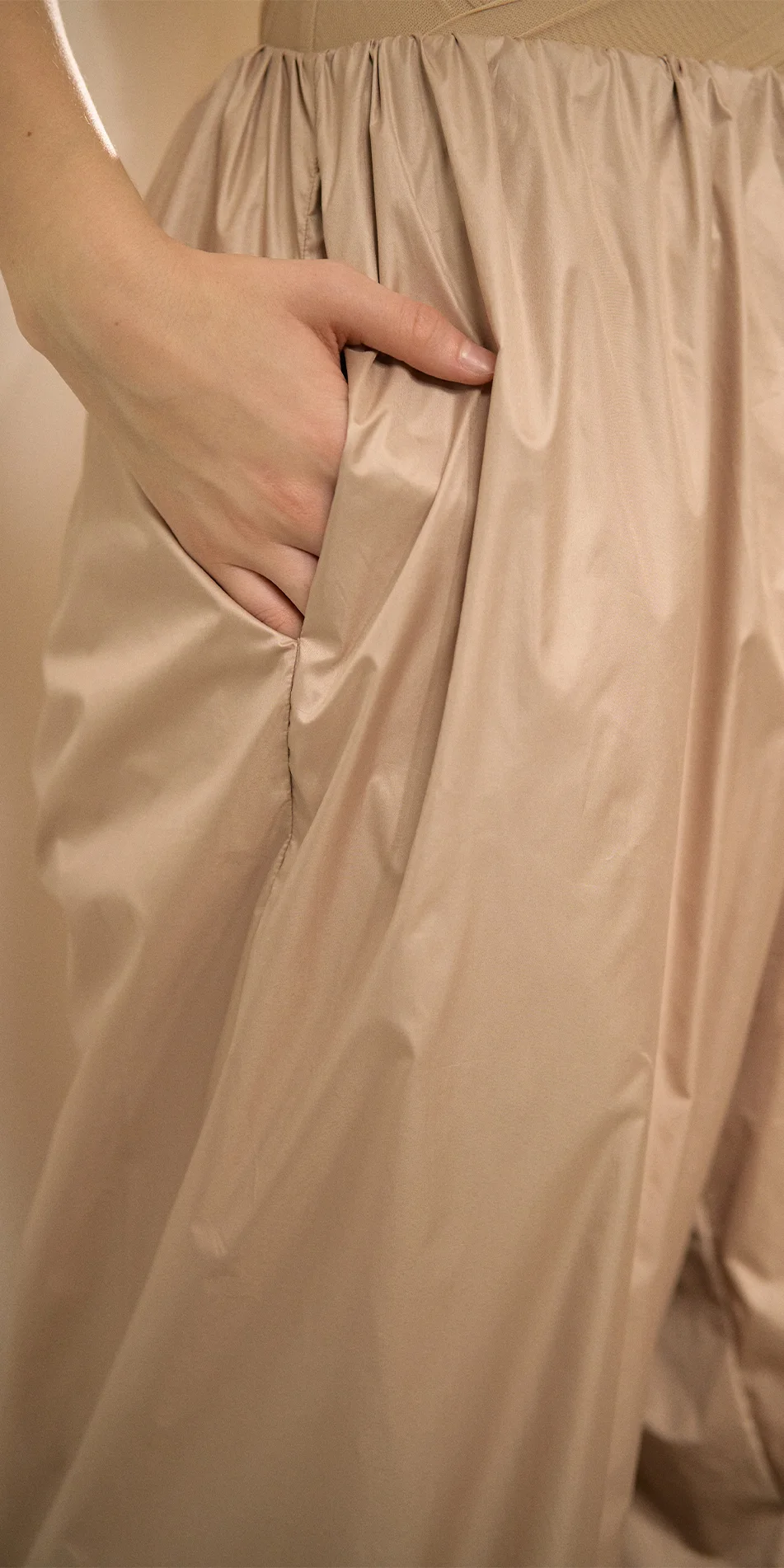 Womens lightweight baggy pants in light beige close up of hand in the pocket left