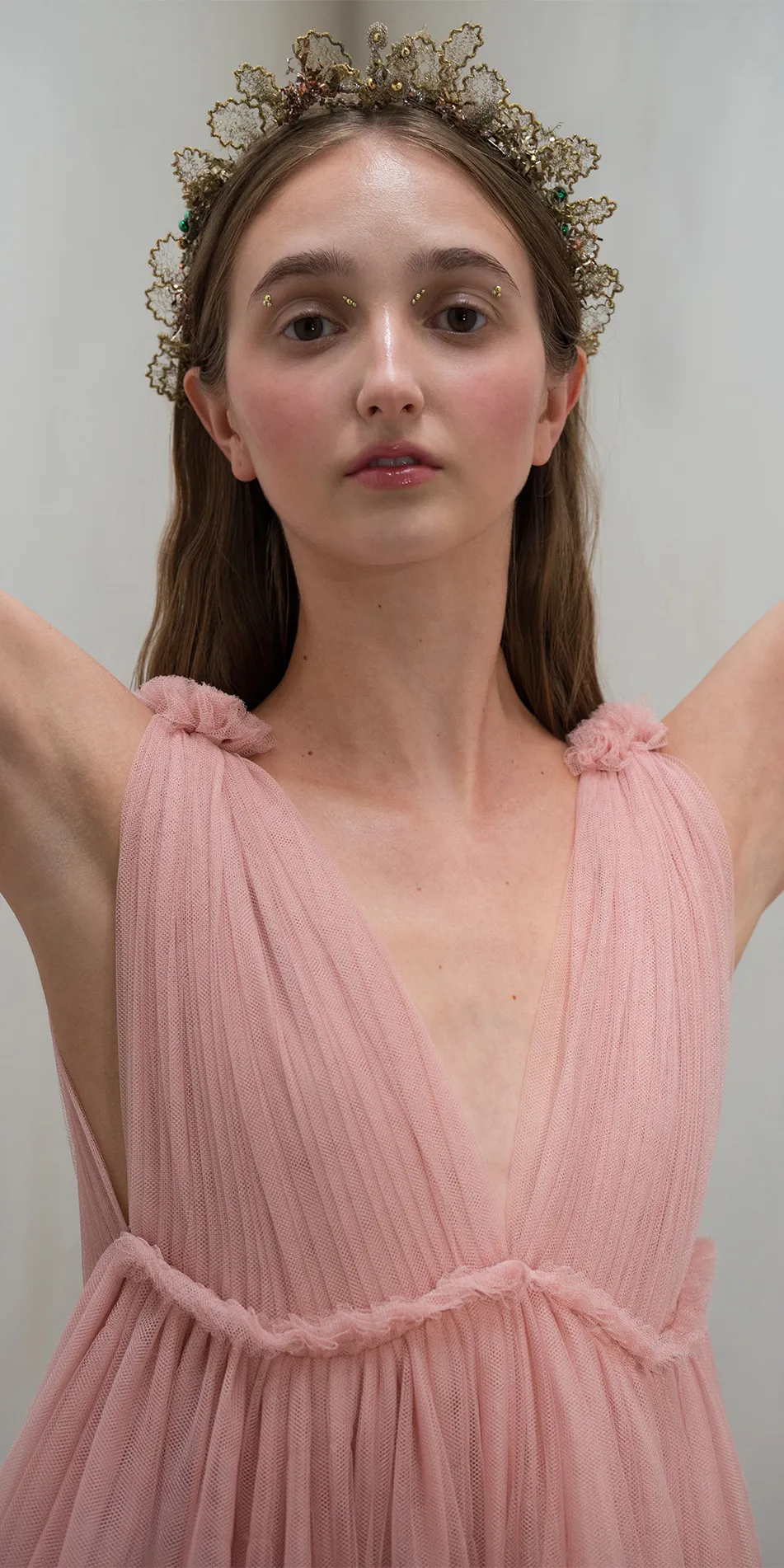 Tulle split neck babydoll dress in dusty pink front close up arms lifted